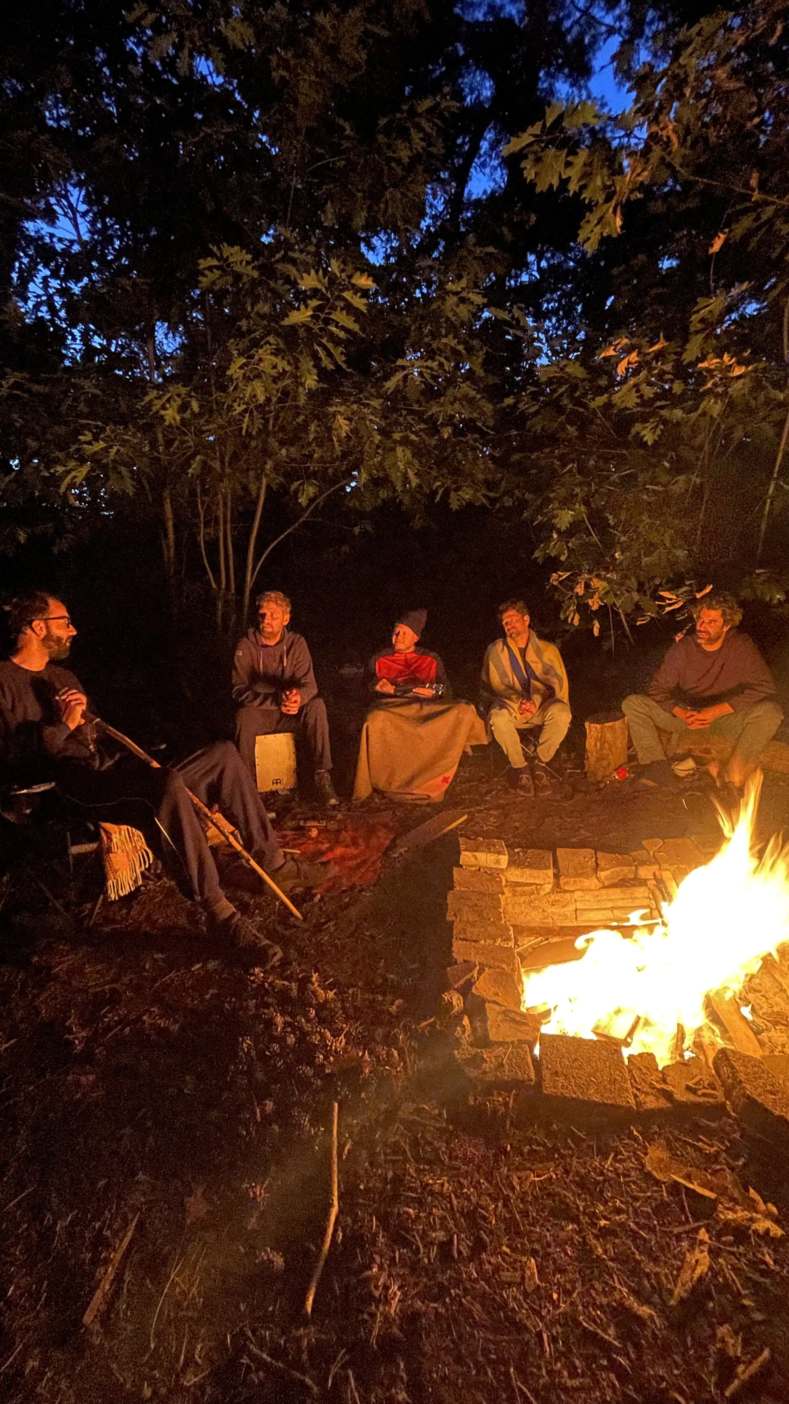 Mannen van de MANA community rond een vuur
